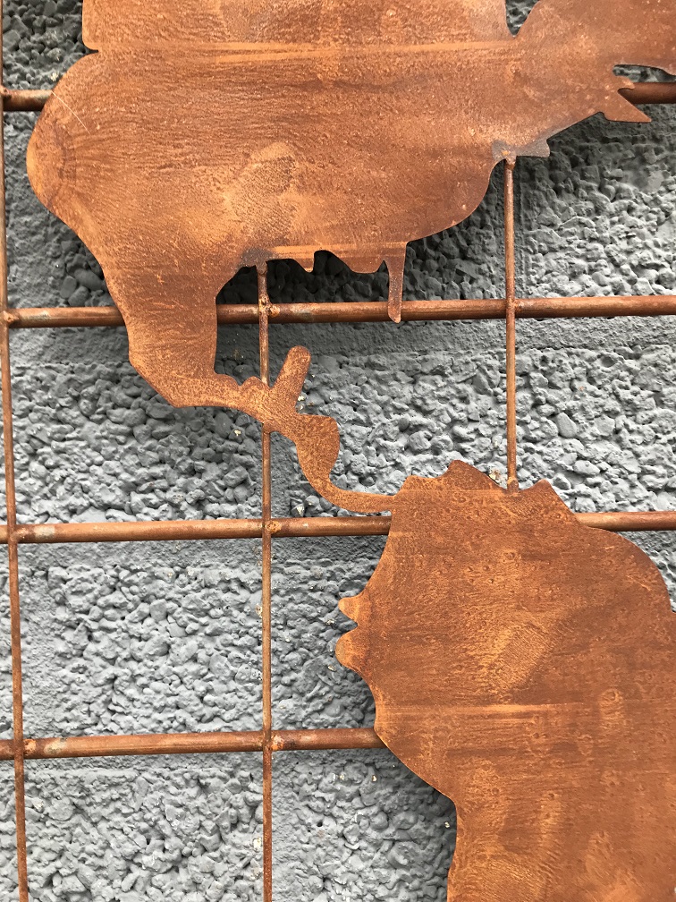 Een ijzeren wandrek met hierop een wereldkaart, robuuste uitstraling