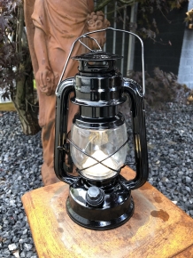 Een antiek uitziende olie-storm-lamp metaal zwart met led verlichting.