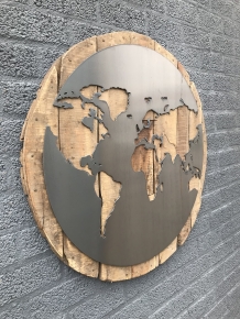 Ein großes Wandornament aus Holz mit einer Welt darauf, ein Meer aus Metall