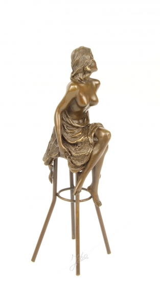 Eine Bronzeskulptur einer barbusigen Dame auf einem Barhocker