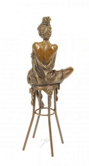 Een bronzen beeld van een dame op barkruk.