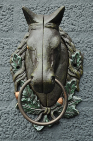 Paardenhoofd met ring, gietijzer bruin.