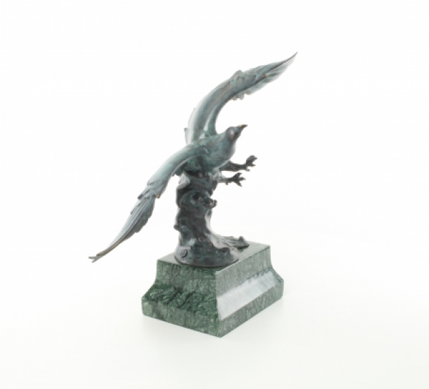 Een bronzen beeld/sculptuur van een adelaar die vliegt
