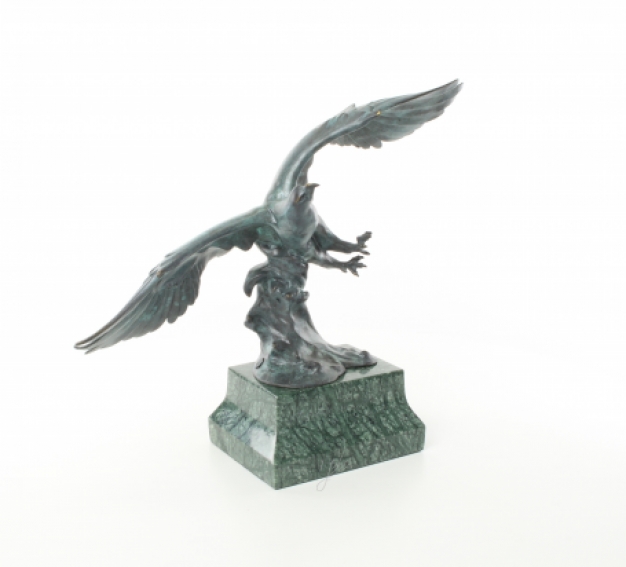 Een bronzen beeld/sculptuur van een adelaar die vliegt