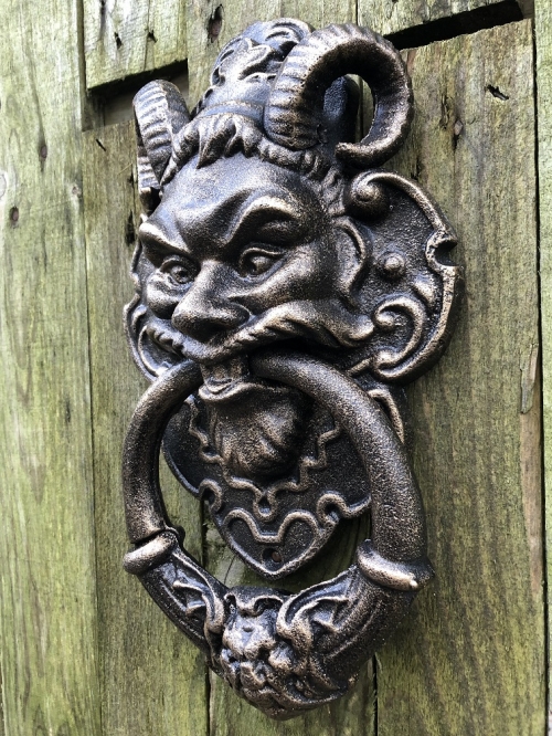 Gietijzeren bronskleurige deurklopper met hoofd van de duivel.