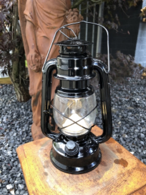 Een antiek uitziende olie-storm-lamp metaal zwart met led verlichting.