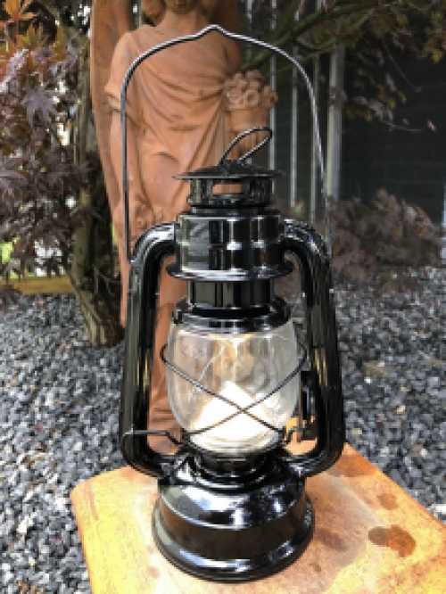 Eine antik aussehende Öl-Windlichtlampe aus schwarzem Metall mit LED-Beleuchtung