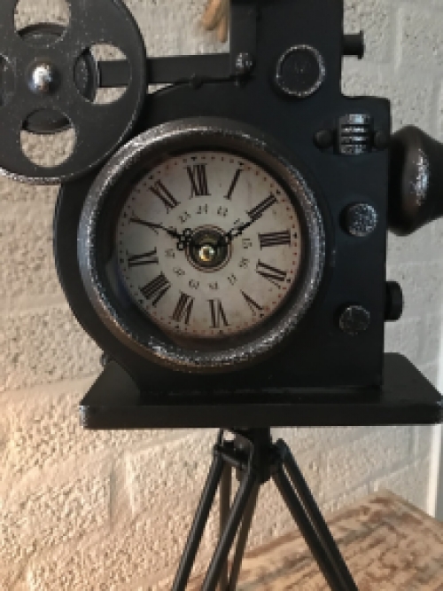 Een nostalgische en decoratieve klok in de vorm van een oude filmcamera