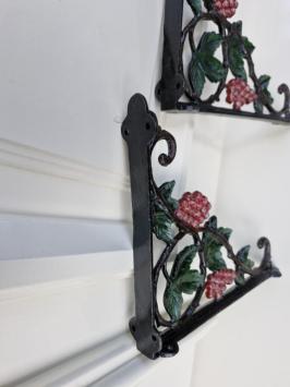 Een paar gietijzeren muurbeugels