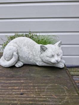 Gartenstatue einer Katze, Gänseblümchen