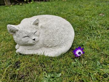 Zusammengekauerte, lebensecht wirkende Katze, Beton