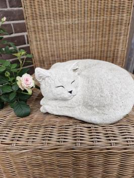 Zusammengekauerte, lebensecht wirkende Katze, Beton