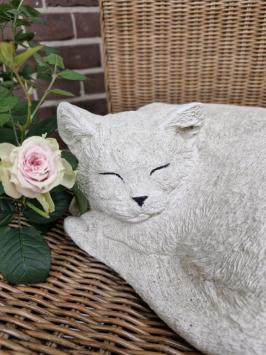 Zusammengekauerte, lebensecht wirkende Katze, Beton