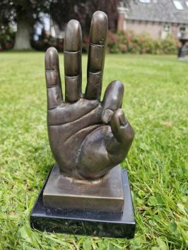 Bronzen beeld van hand met  'OK' handgebaar.