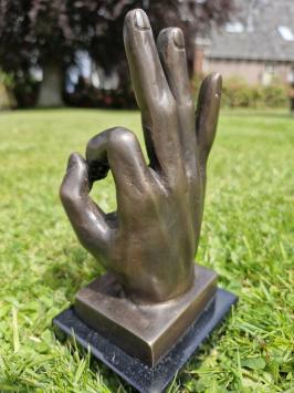 Bronzen beeld van hand met  'OK' handgebaar.