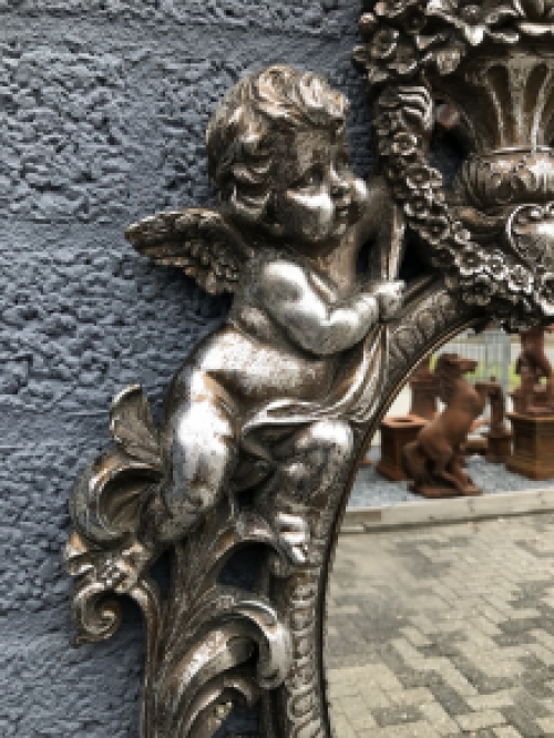 Ein feiner dekorativer Spiegel, silbern umrahmt mit einem Kranz, der von 2 Engeln getragen wird