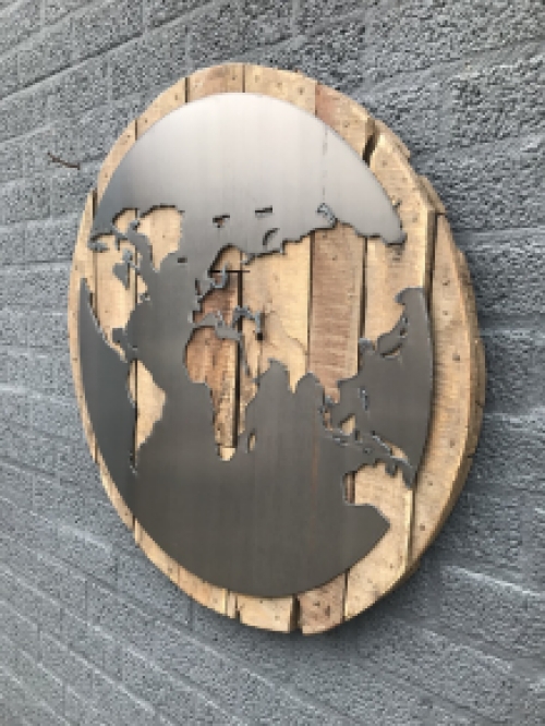 Ein großes Wandornament aus Holz mit einer Welt darauf, ein Meer aus Metall