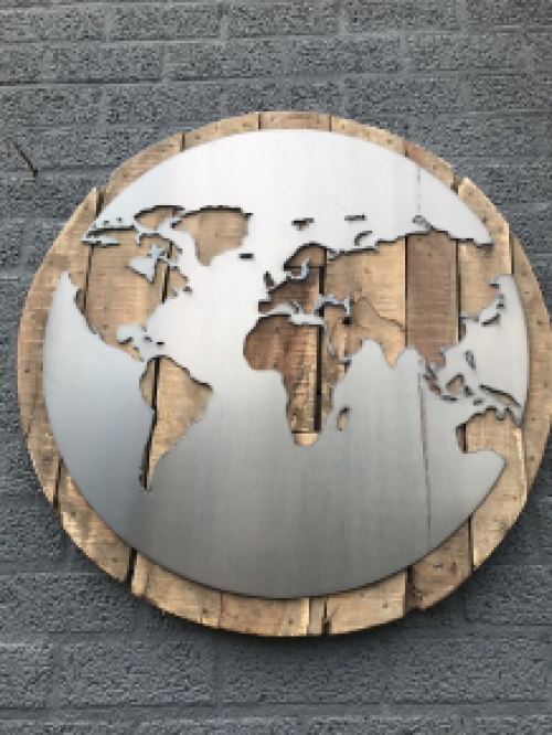 Ein großes Wandornament aus Holz mit einer Welt darauf, ein Meer aus Metall
