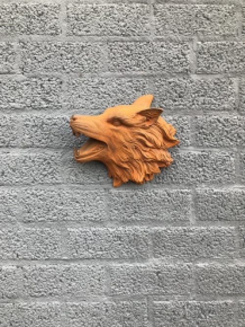 Wolvenkop, gietijzeren wandornament met een rustiek oppervlak